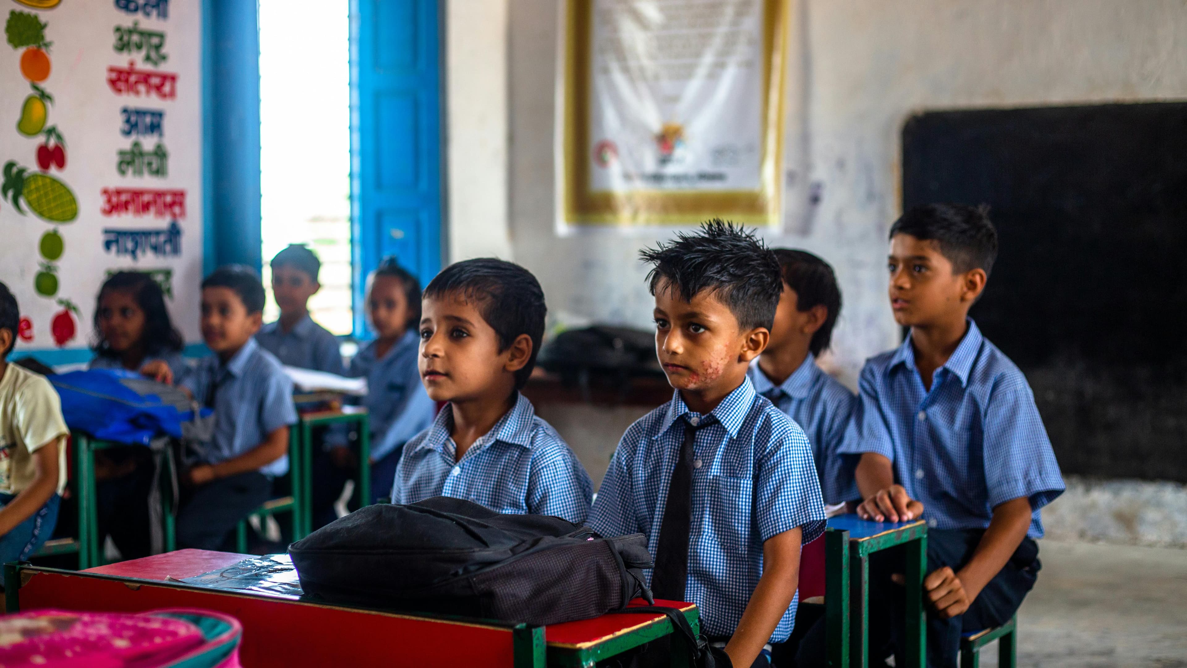 Children sitting in a classroom with desks and chairs